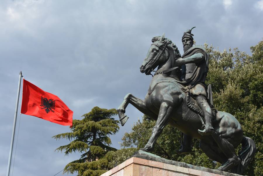 Esultura del héroe nacional, Skandeberg, junto a la bandera de Albania.